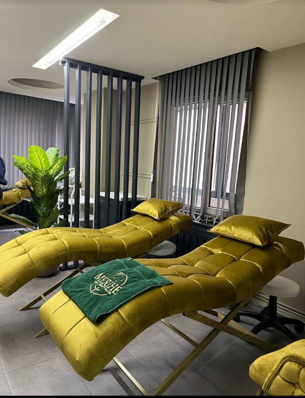 Merihe Beauty salonunda zeytin yeşili kadife bakım koltukları ve marka havlusu